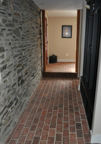 Thin brick hallway floor with stone walls